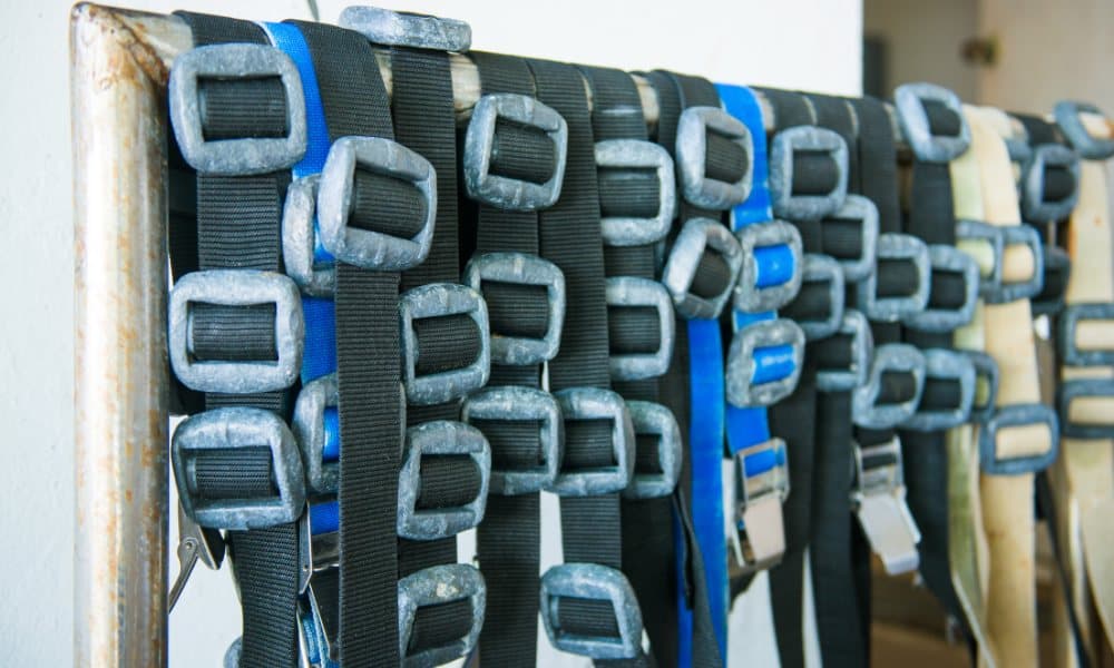 Weight belts with lead weights hung in a row on a rack